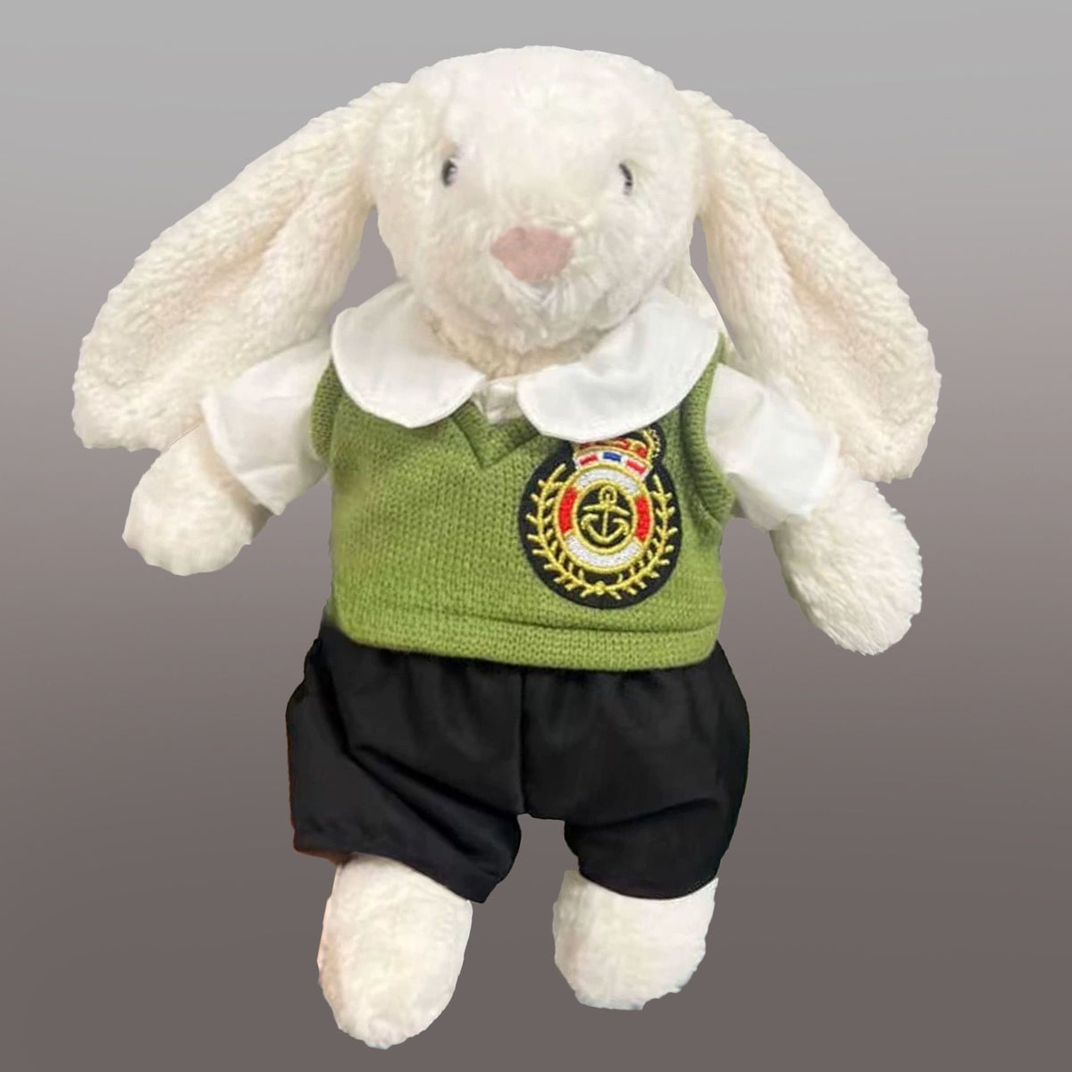 Cream Bashful Bunny modelling a white rounded-collar top, olive-green vest with an anchor crest and black shorts