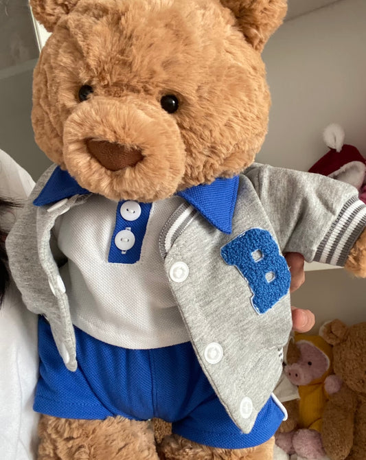Close up of grey varsity jacket with chenille blue B patch on a teddy bear