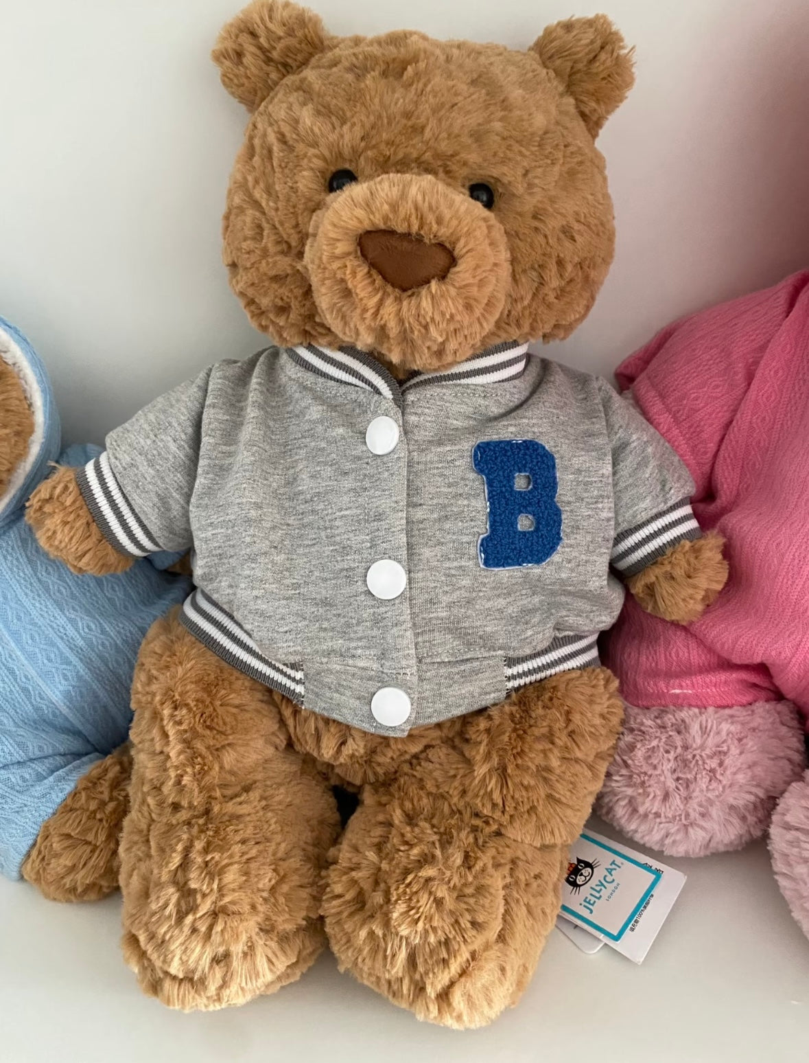 White polo top with royal blue collar and blue shorts on a teddy bear