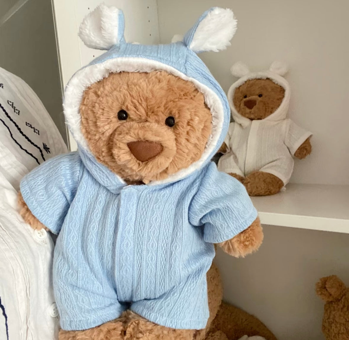 Close up of textured knit bunny-ear hooded romper on a teddy bear