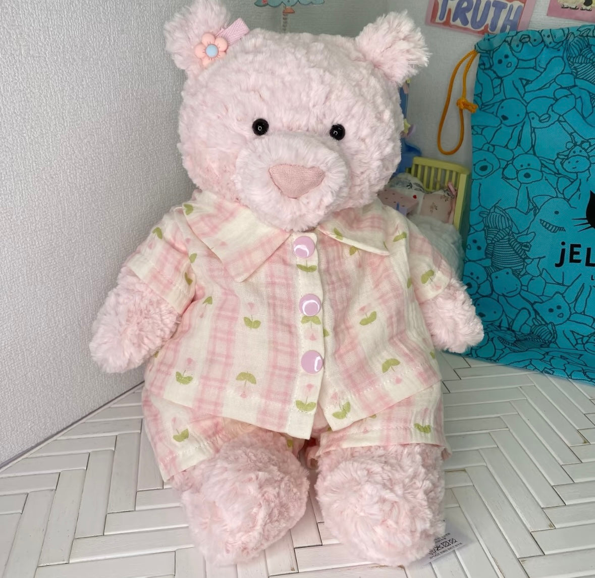 Pink teddy bear wearing a cherry print gingham pyjama shirt and matching bottoms