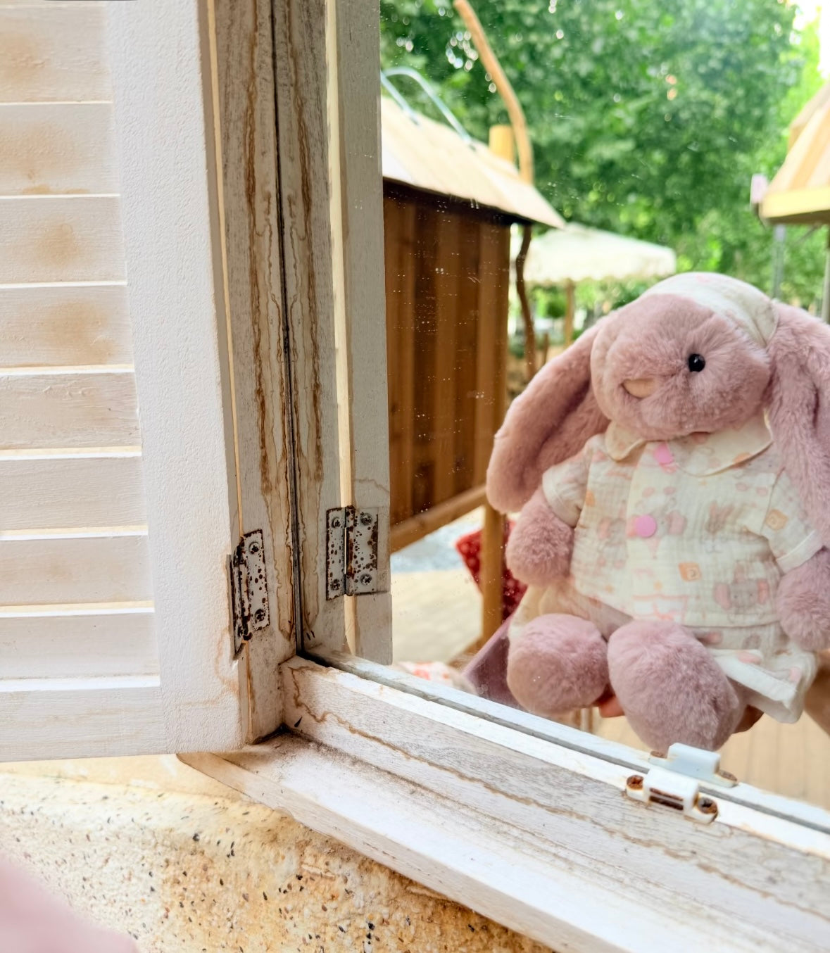 Pink bunny modelling a cream pastel pyjama top, matching bottoms and cap