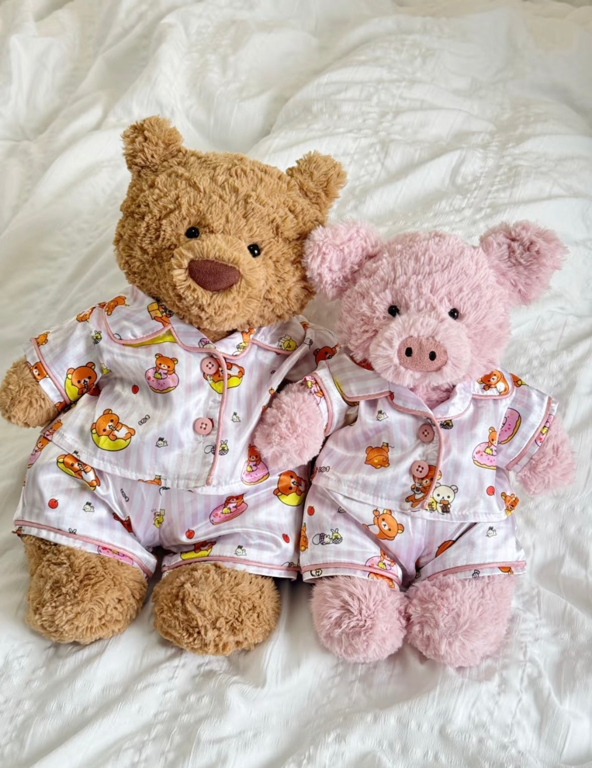 Bear and pink pig plush toys wearing pink Rilakkuma-print pyjama tops and matching shorts.