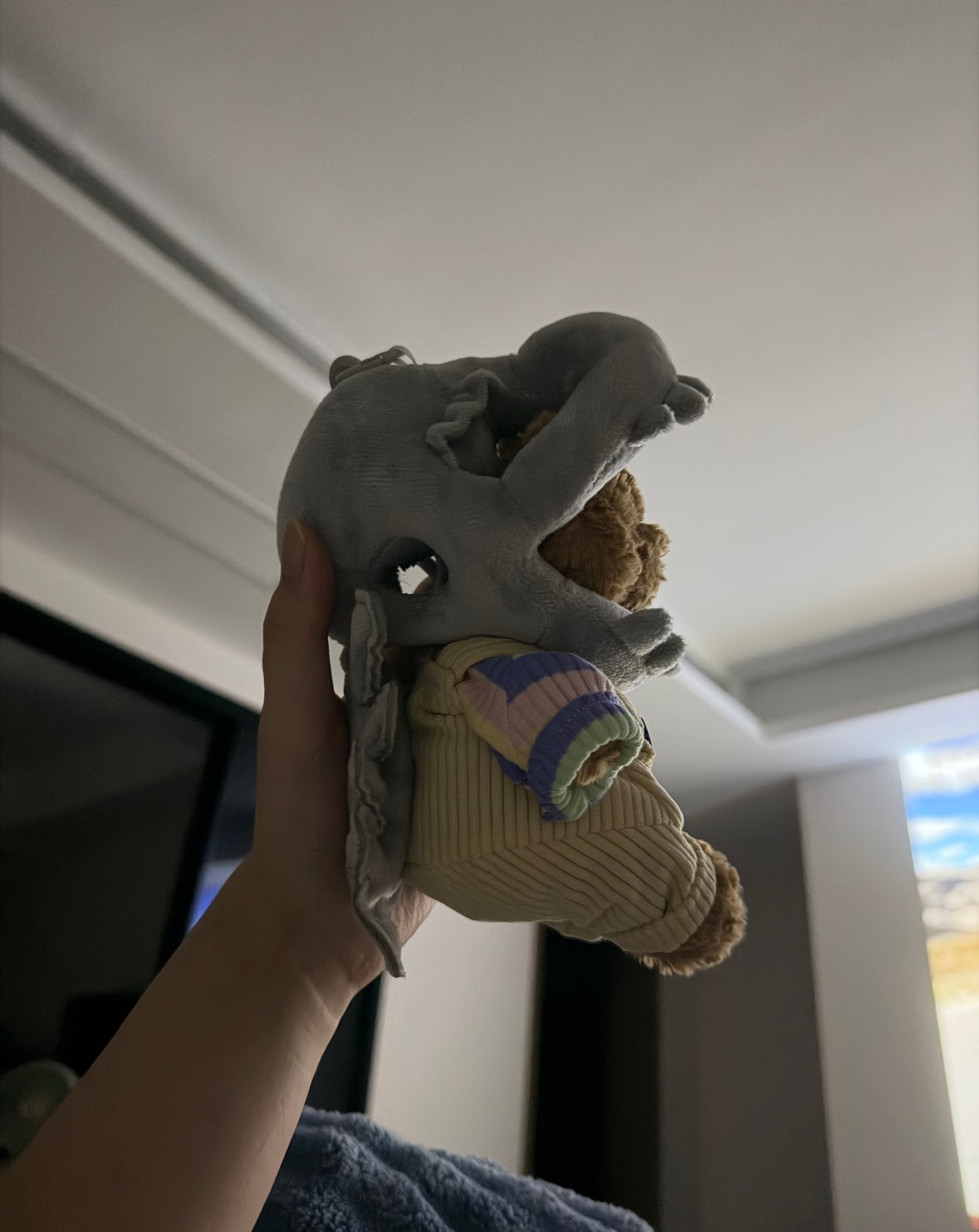 Side view of the grey shark headpiece and pale yellow dungarees worn by a plush bear