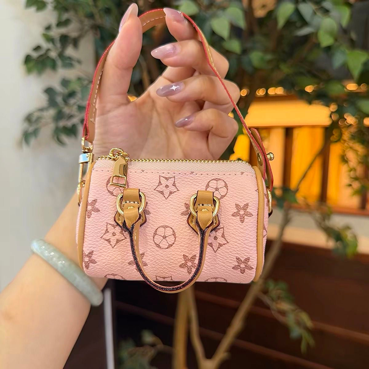 Mini black bucket bag with multicoloured motifs and a tan drawstring