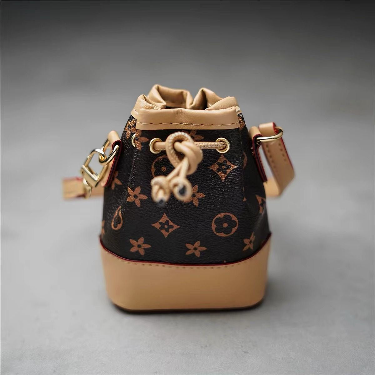 Mini white bucket bag with grey motifs and tan trim