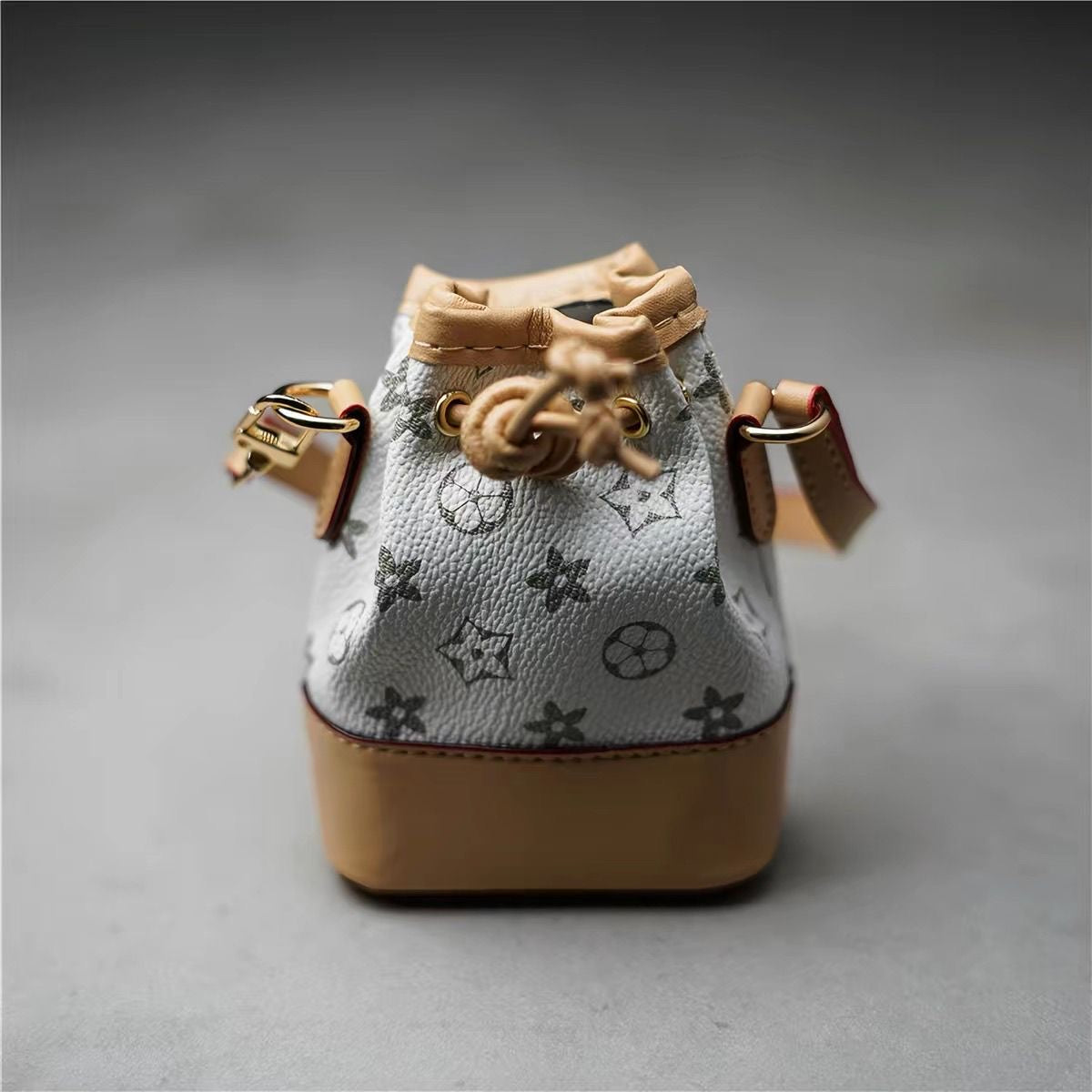 Mini pink patterned handbag with twin handles and a long strap
