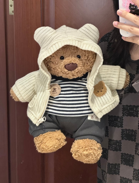 Bartholomew Bear wearing cream knit hoodie set with striped tee and grey trousers