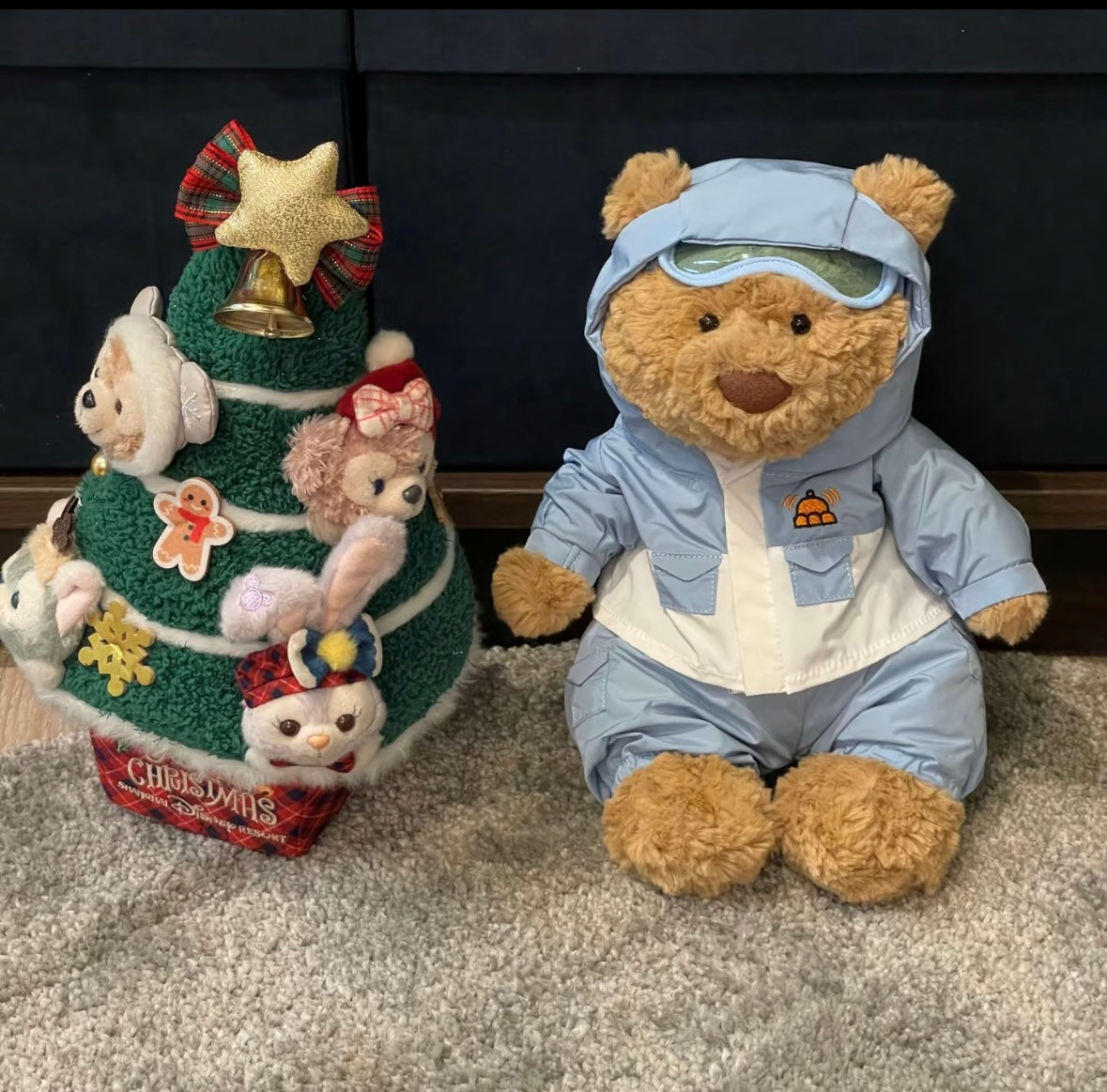 Large bear in blue snow suit next to Christmas Duffy tree display