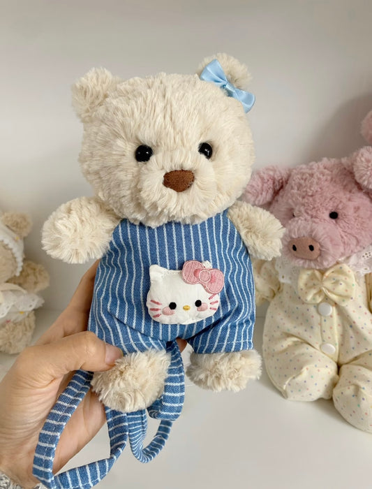 Close-up of blue striped dungaree with Hello Kitty embroidered patch, held in hand
