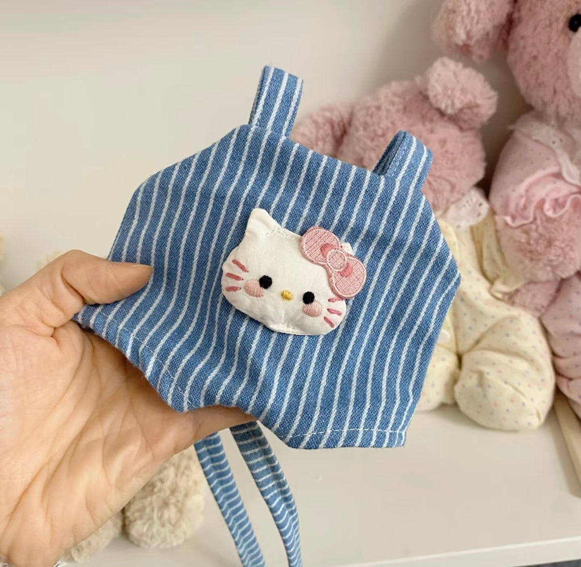Jellycat Bartholomew Bear wearing blue striped Hello Kitty dungaree, front view