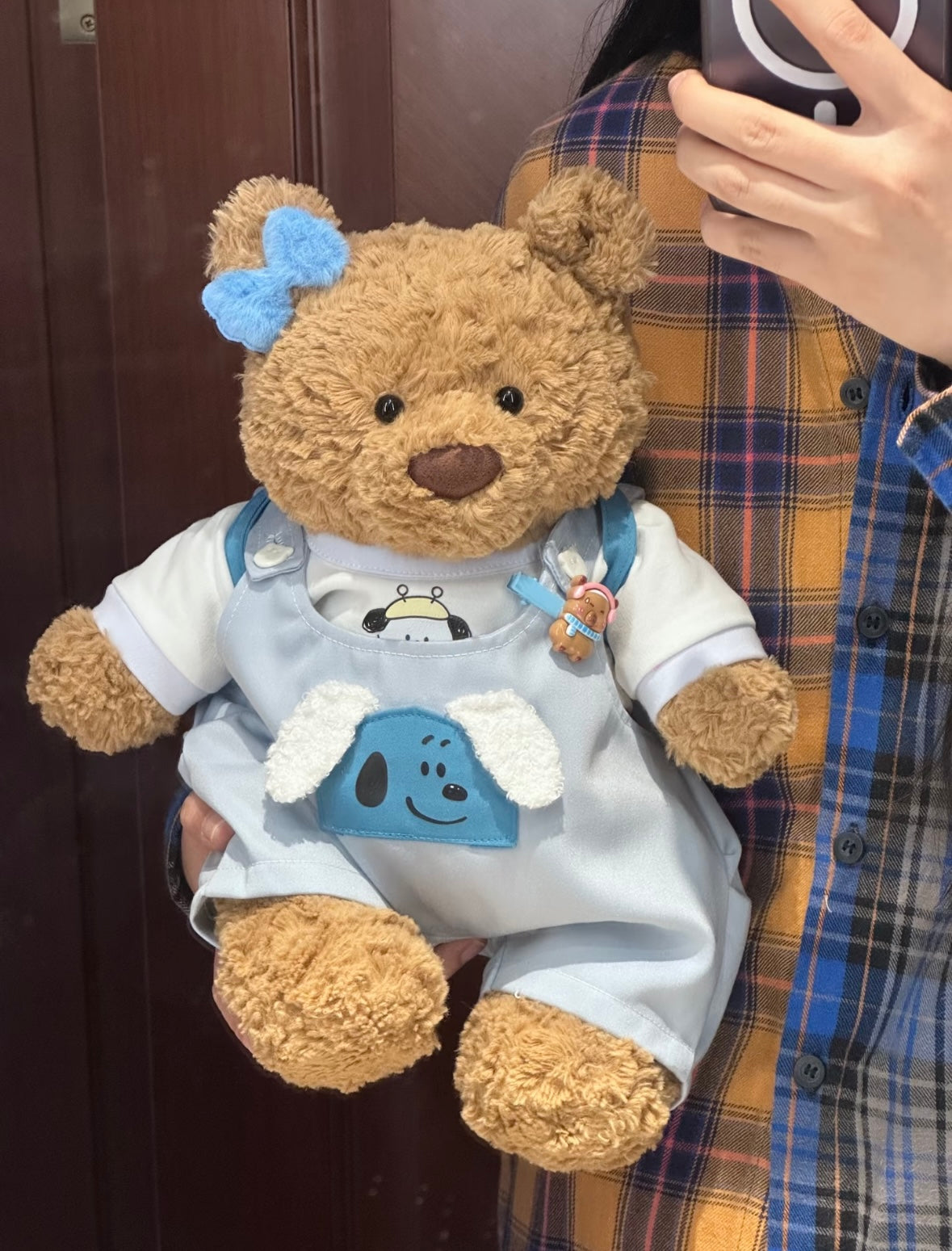 Bartholomew Bear wearing baby blue Snoopy dungaree set, back view showing round blue backpack