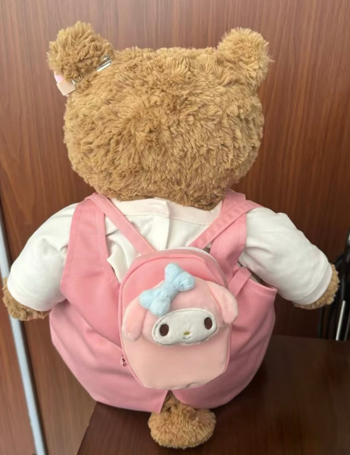 Bartholomew Bear wearing pink piggy dungaree set, back view showing My Melody backpack
