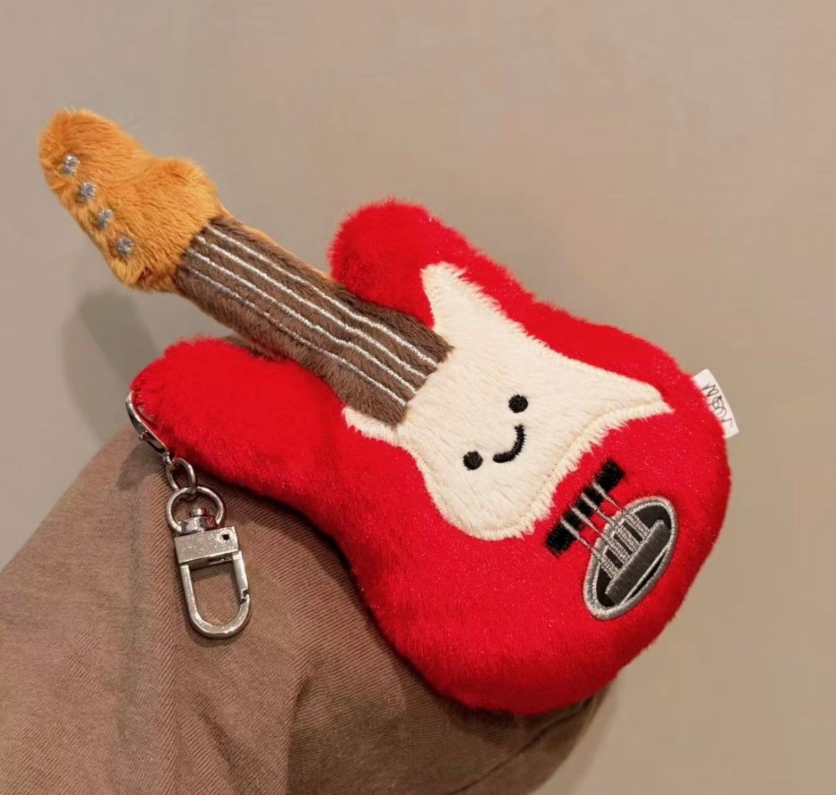 Four electric guitar bag charms in pink, blue, red and mint