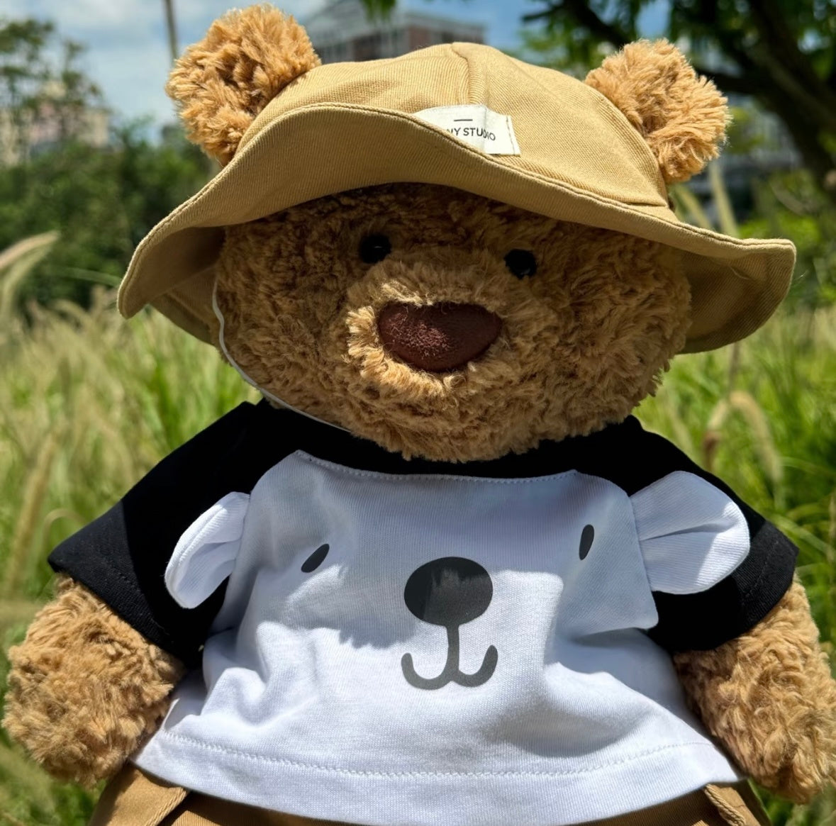Close-up of Bartholomew Bear in bear face tee and khaki bucket hat