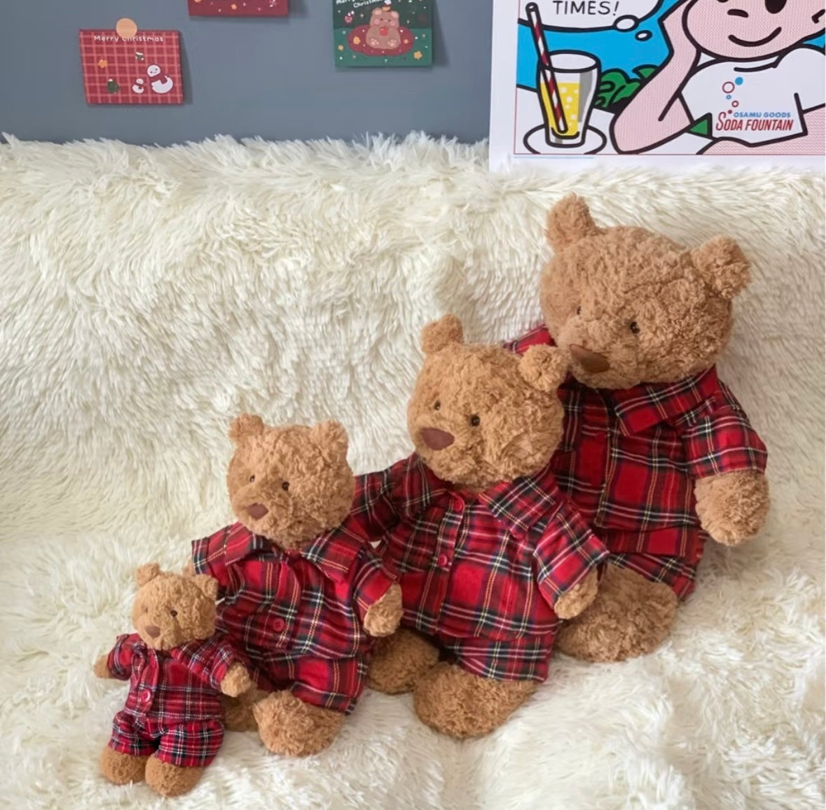 Three Jellycat bears in red tartan pyjamas lying on fluffy rug