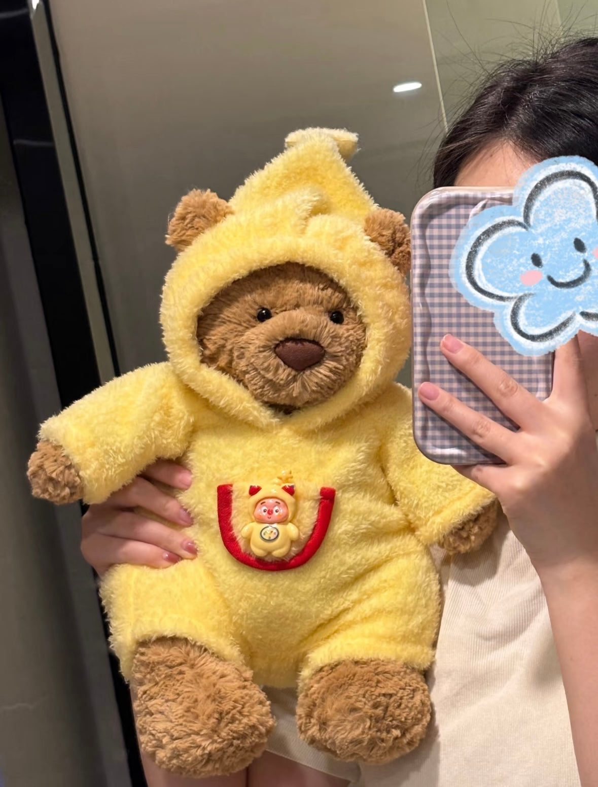 Bartholomew Bear wearing bright yellow chick onesie with pointed hood and character badge
