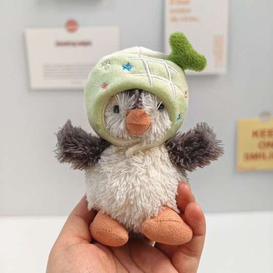 Jellycat Peanut Penguin wearing green avocado hat with plush stem