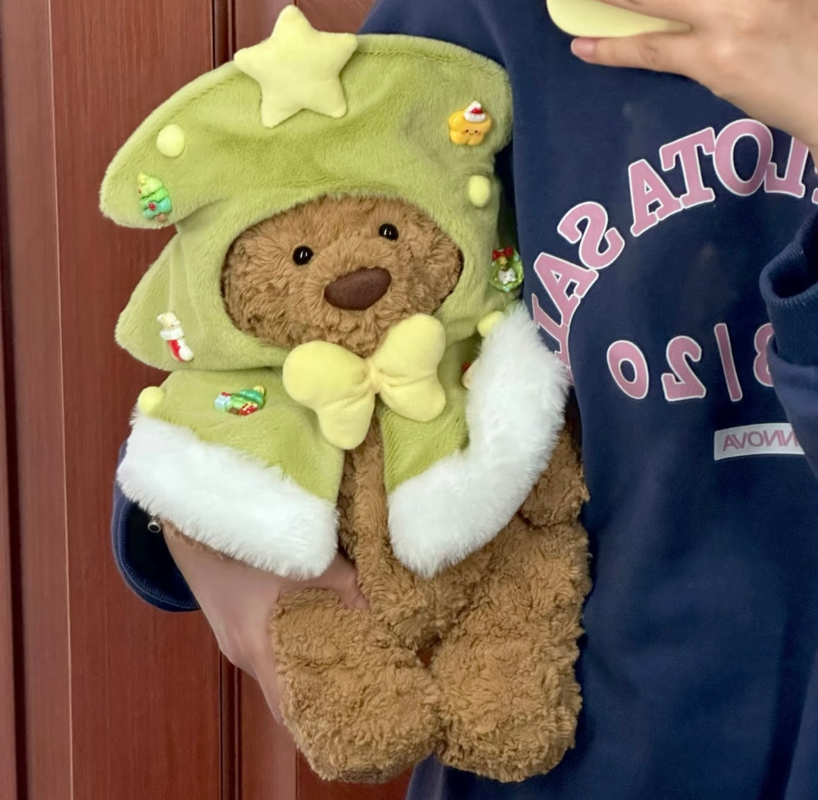 Bartholomew Bear wearing green Christmas tree cape close up front view