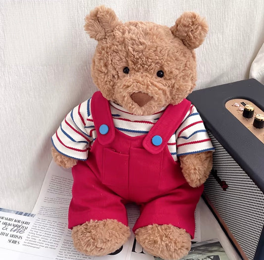Bartholomew Bear wearing red striped dungaree set, seated next to a vintage radio