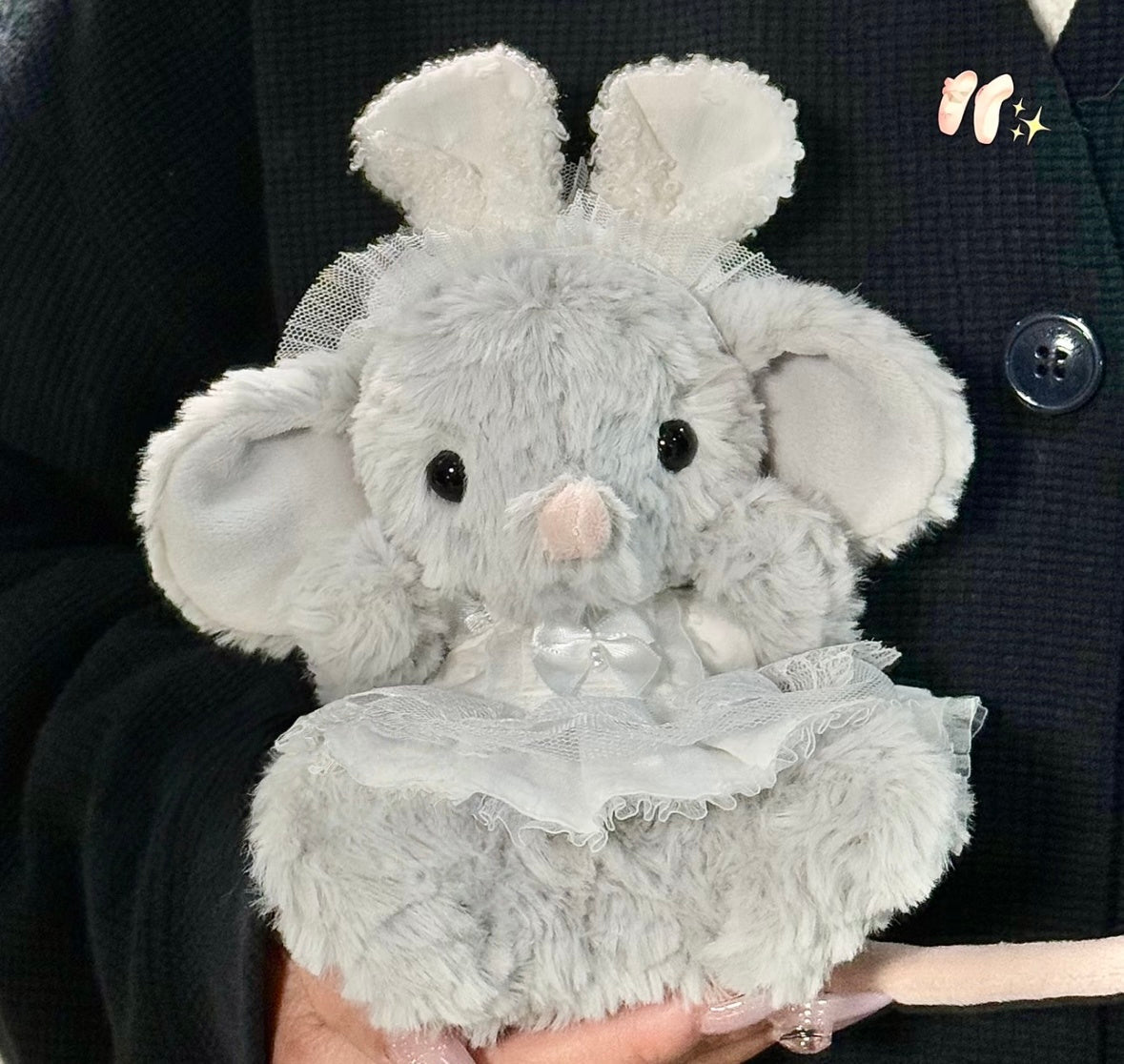 Grey elephant plush wearing a white lace dress with satin bow and tulle bunny ear headband