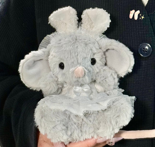Grey elephant plush wearing a white lace dress with satin bow and tulle bunny ear headband