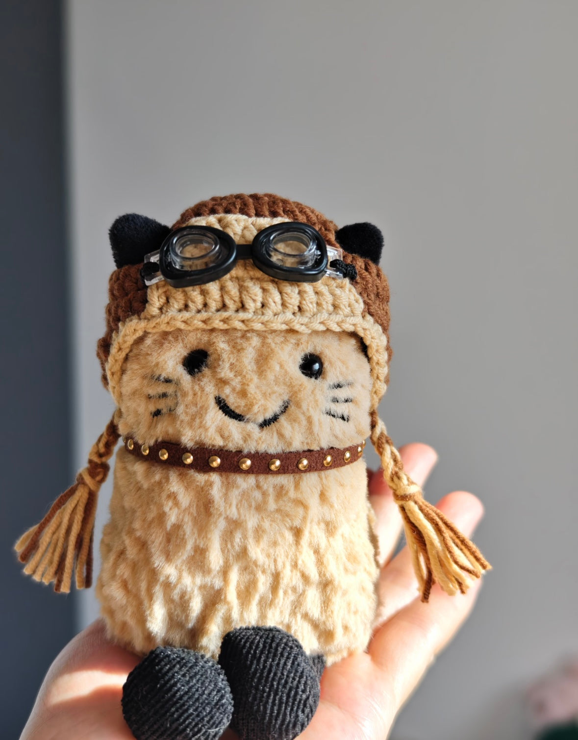 Aviator cat plush holding helmet with goggles
