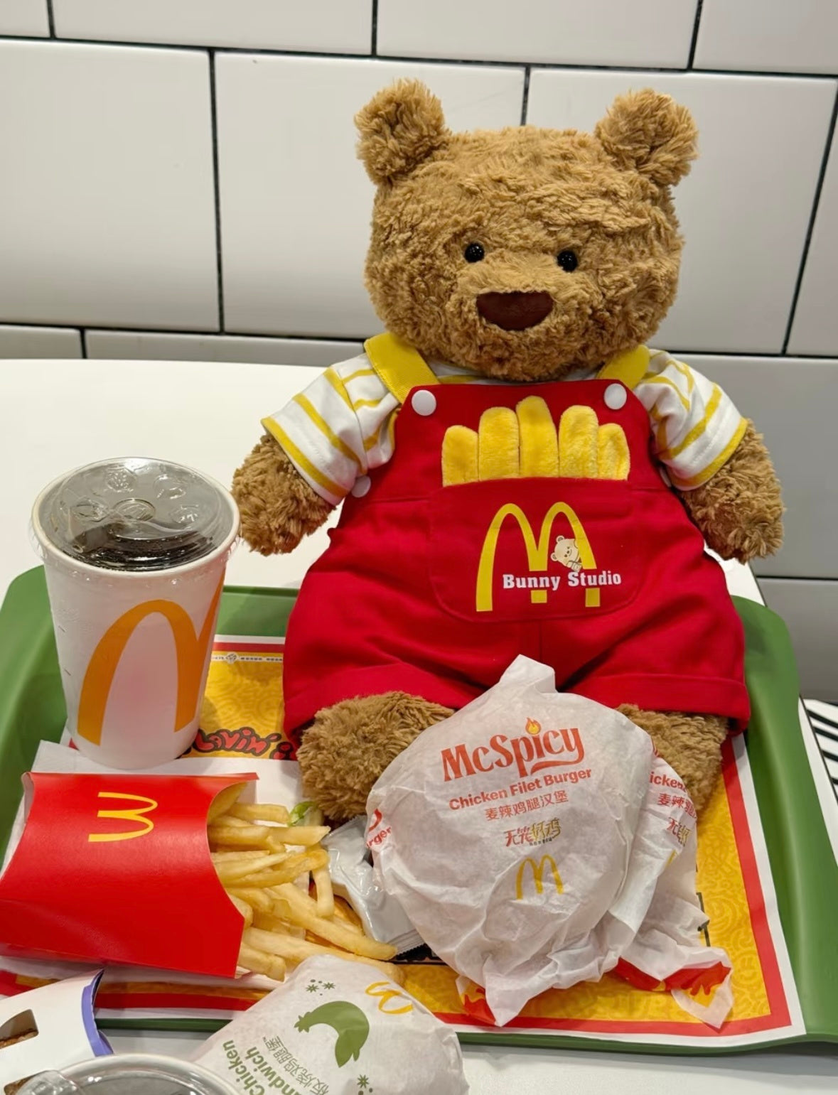 Bartholomew Bear wearing McDonald's dungaree outfit held by Ronald McDonald statue