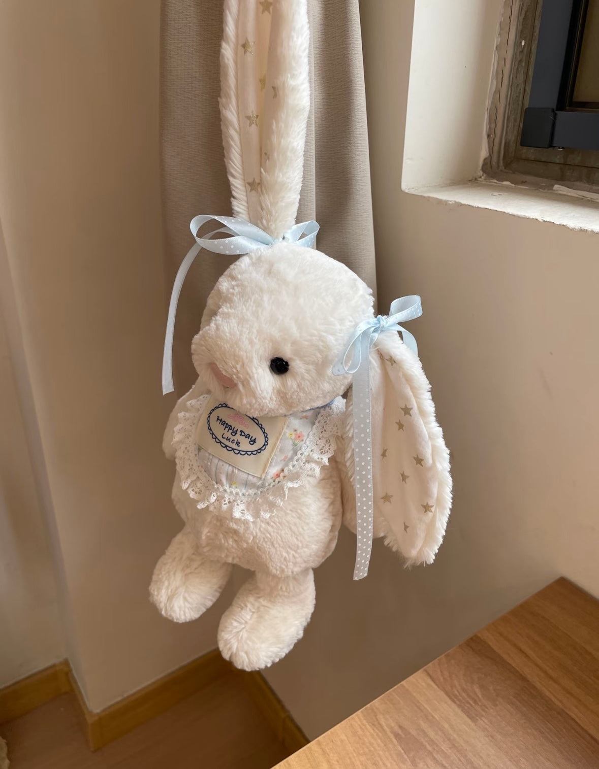 White plush bunny wearing Happy Day Luck lace bib - front view