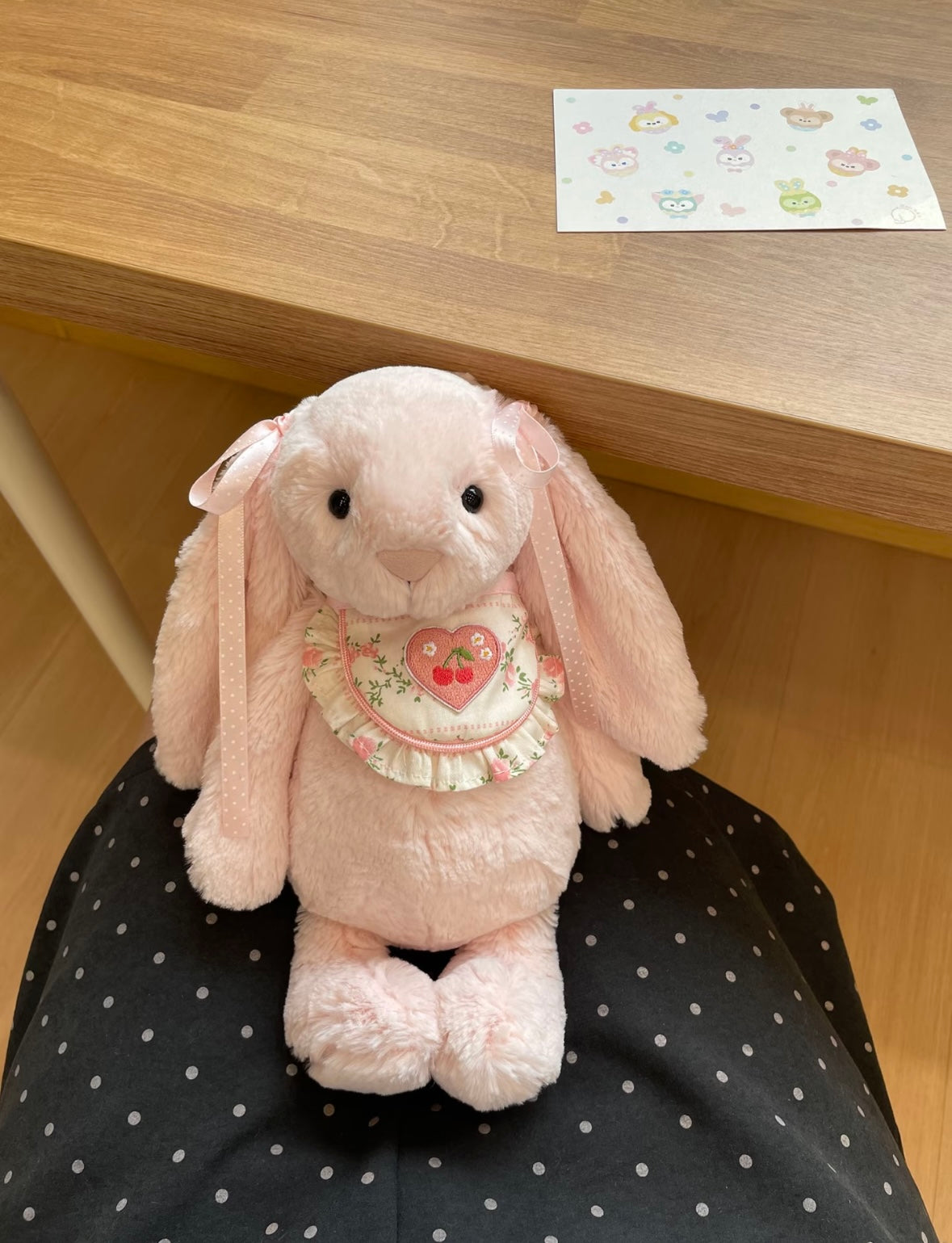 Pink Bashful Bunny wearing Cherry Heart Bib with wicker basket