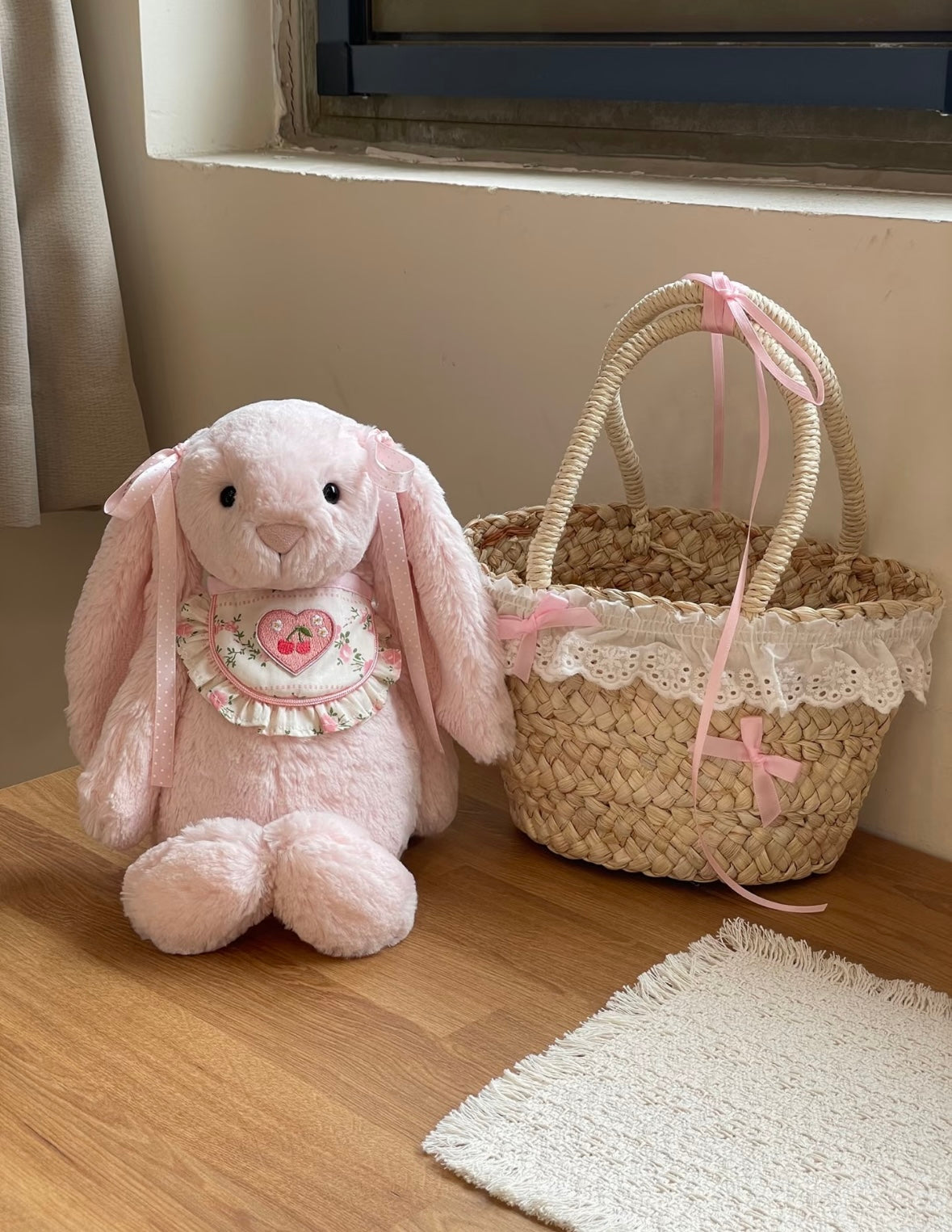 Two beige Bashful Bunnies wearing Cherry Heart Bibs - size comparison