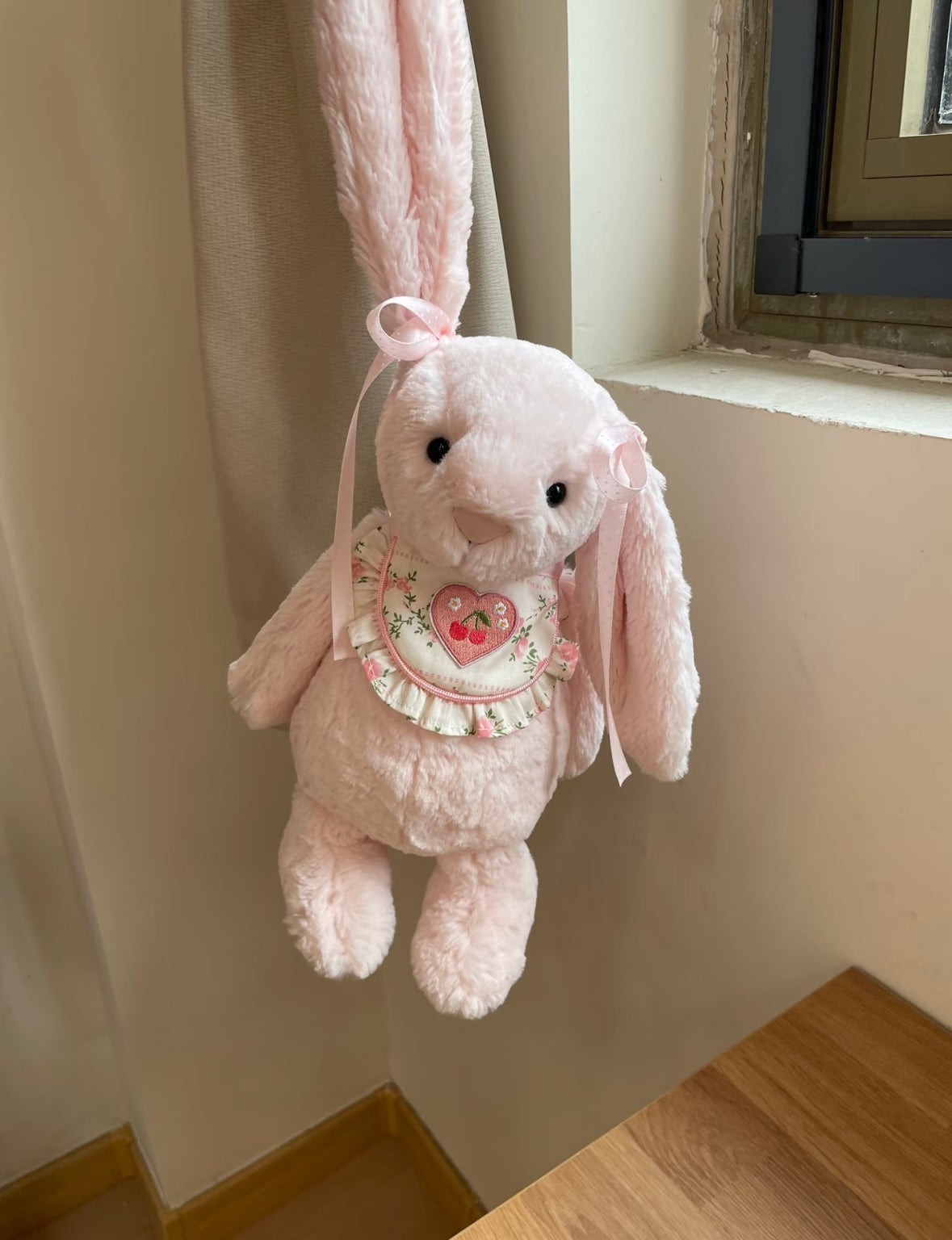 Pink Bashful Bunny wearing Cherry Heart Bib - seated front view