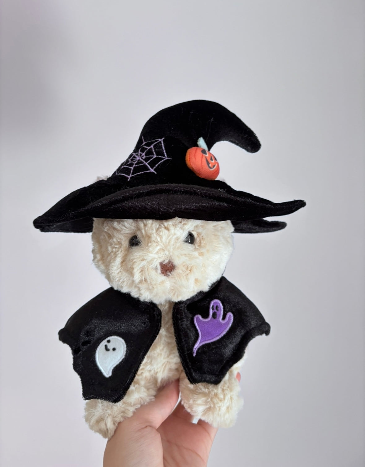 Two plush bears wearing Halloween outfits — orange witch hat with ghost costume and black witch hat with ghost cape