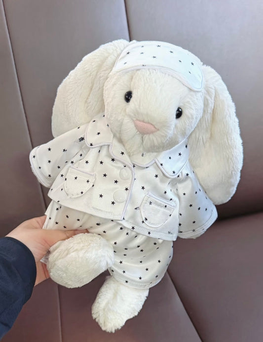 White bunny plushie wearing a star-print pyjama set with matching sleep cap