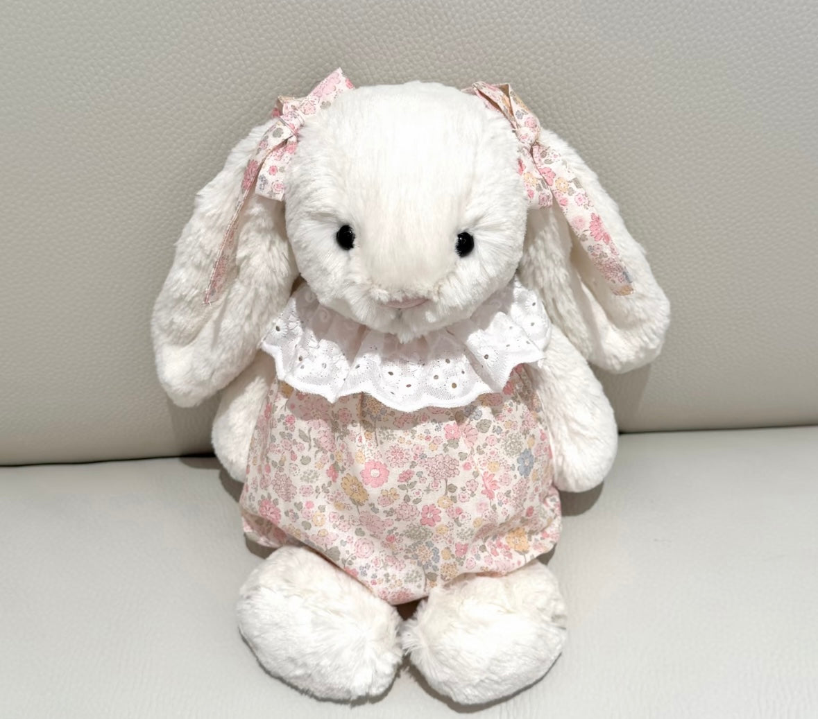 Jellycat Bashful Bunny wearing floral romper with white lace collar and ear ribbons - front view