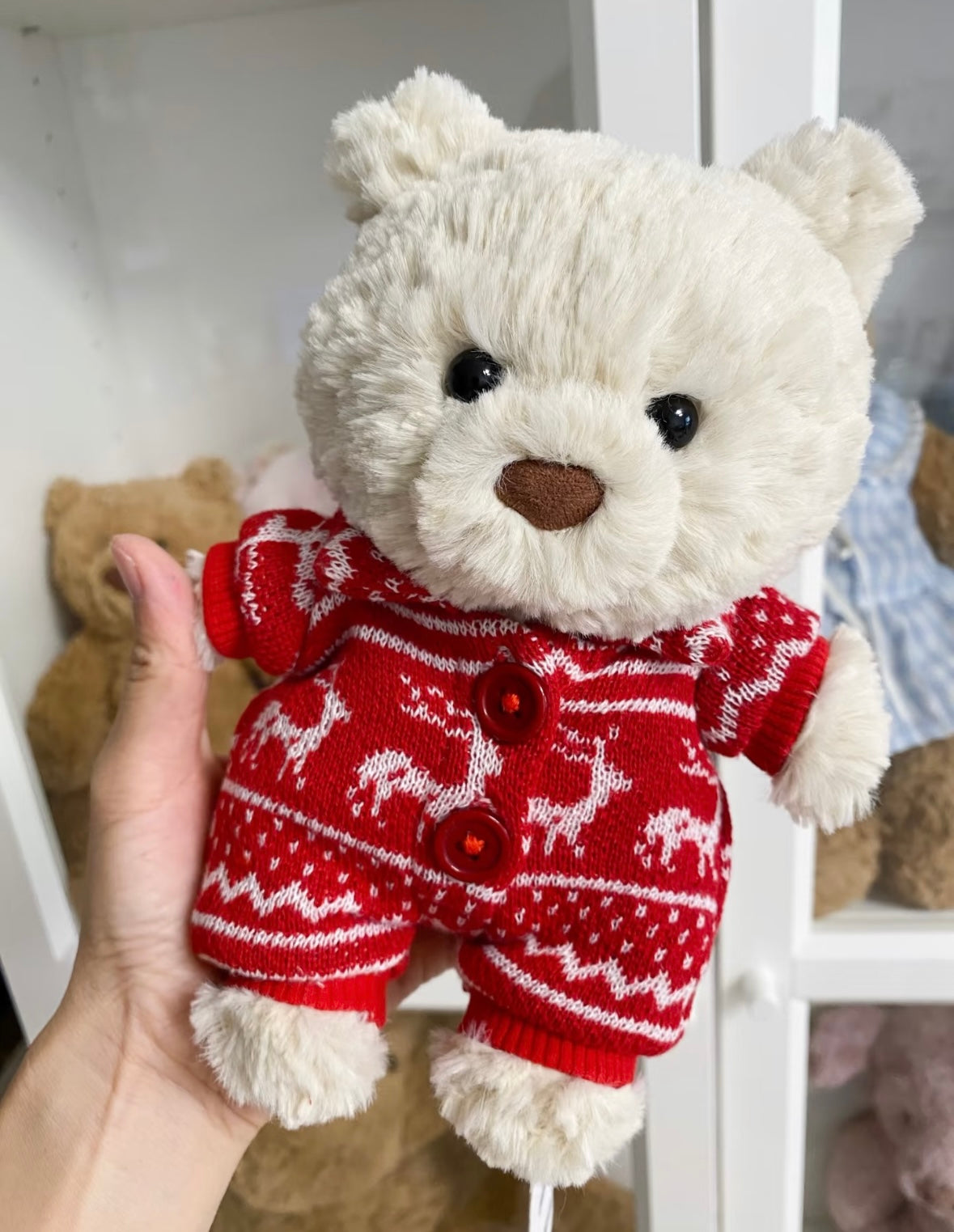 Back view of red Nordic knit romper showing cream pom-pom tail detail