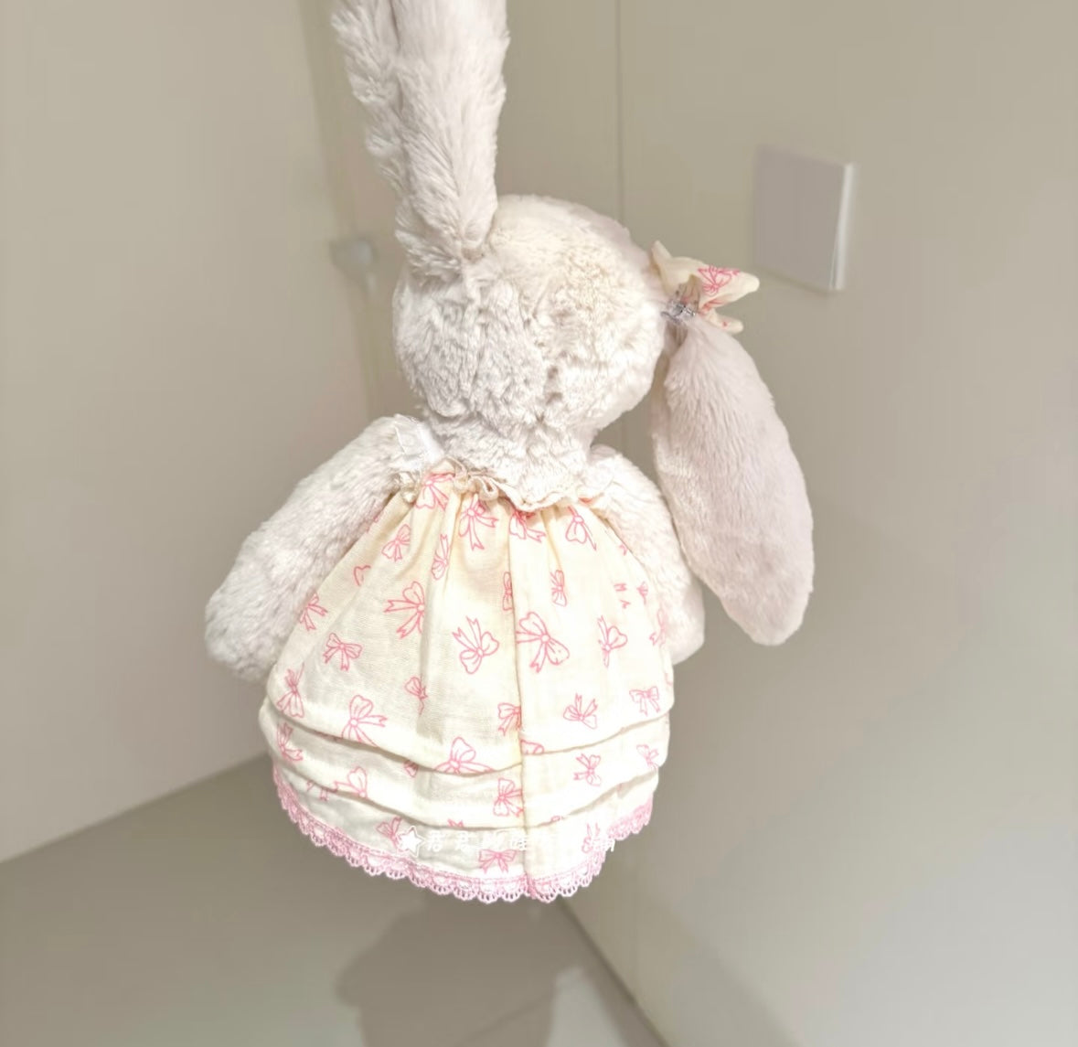 Side view of bunny wearing pink bow skirt set with bow ear clip detail