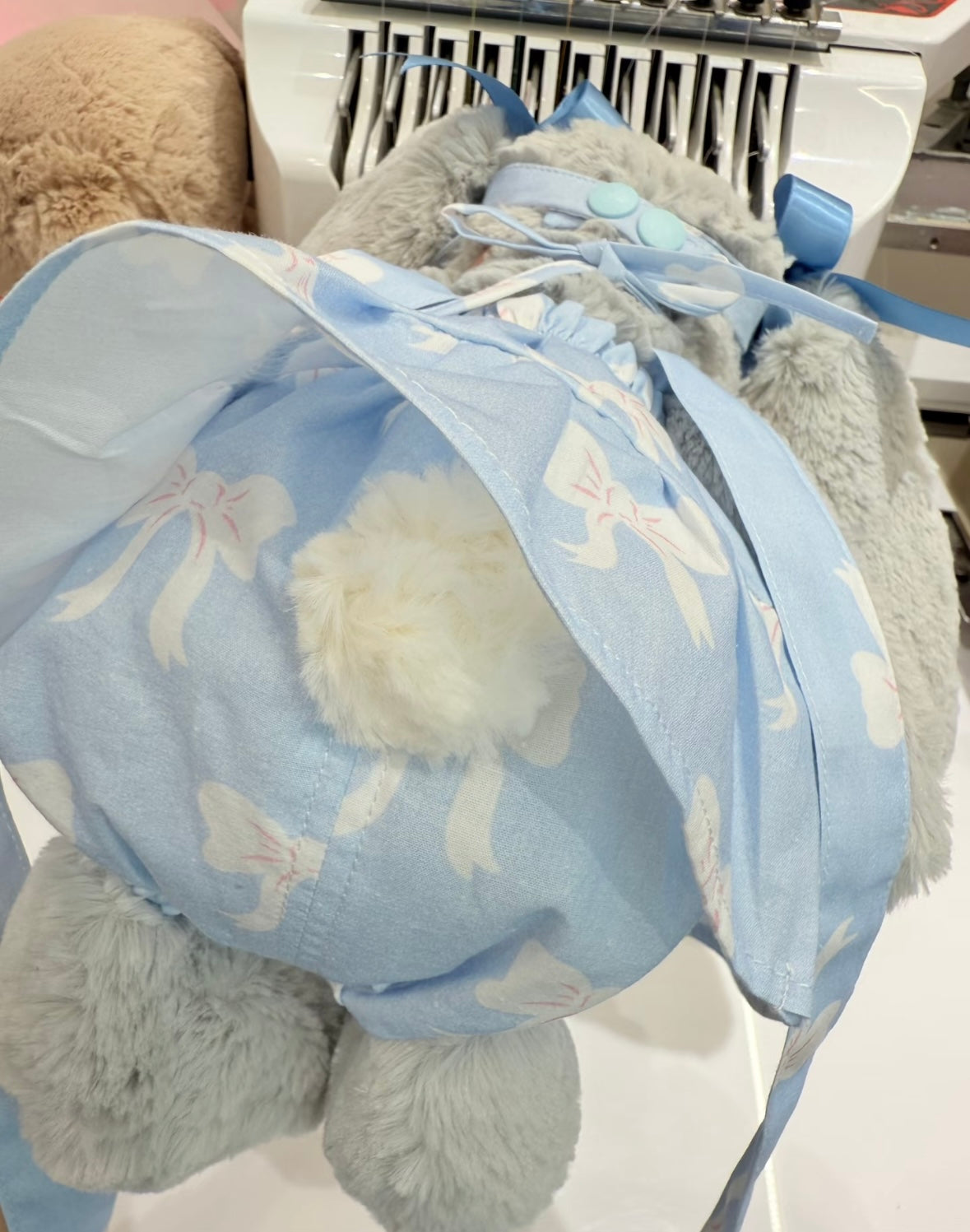Back view showing the blue bow dress and hat ribbon tie detail
