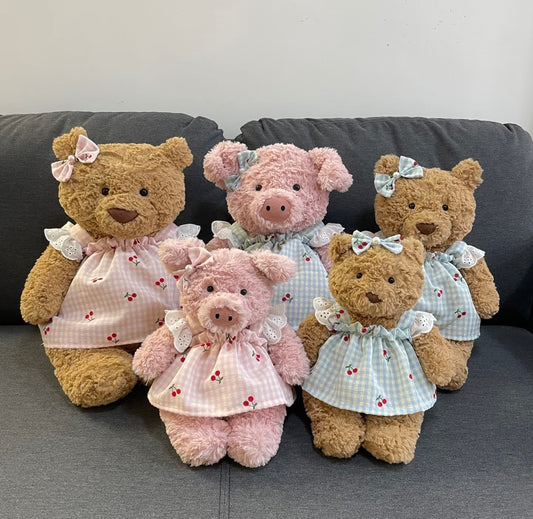 Group photo of cherry gingham dress sets in pink and blue on pink pigs and brown bears