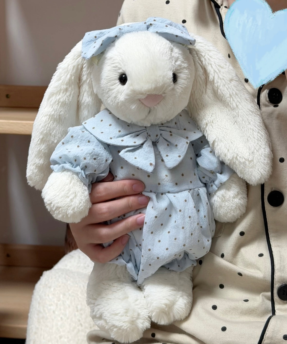 Blue polka dot romper set on white bunny plush - front view