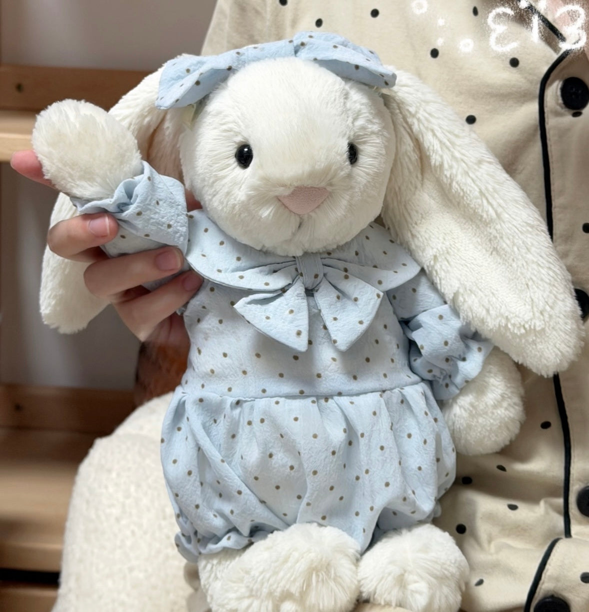 Black polka dot romper set on white bunny plush - front view
