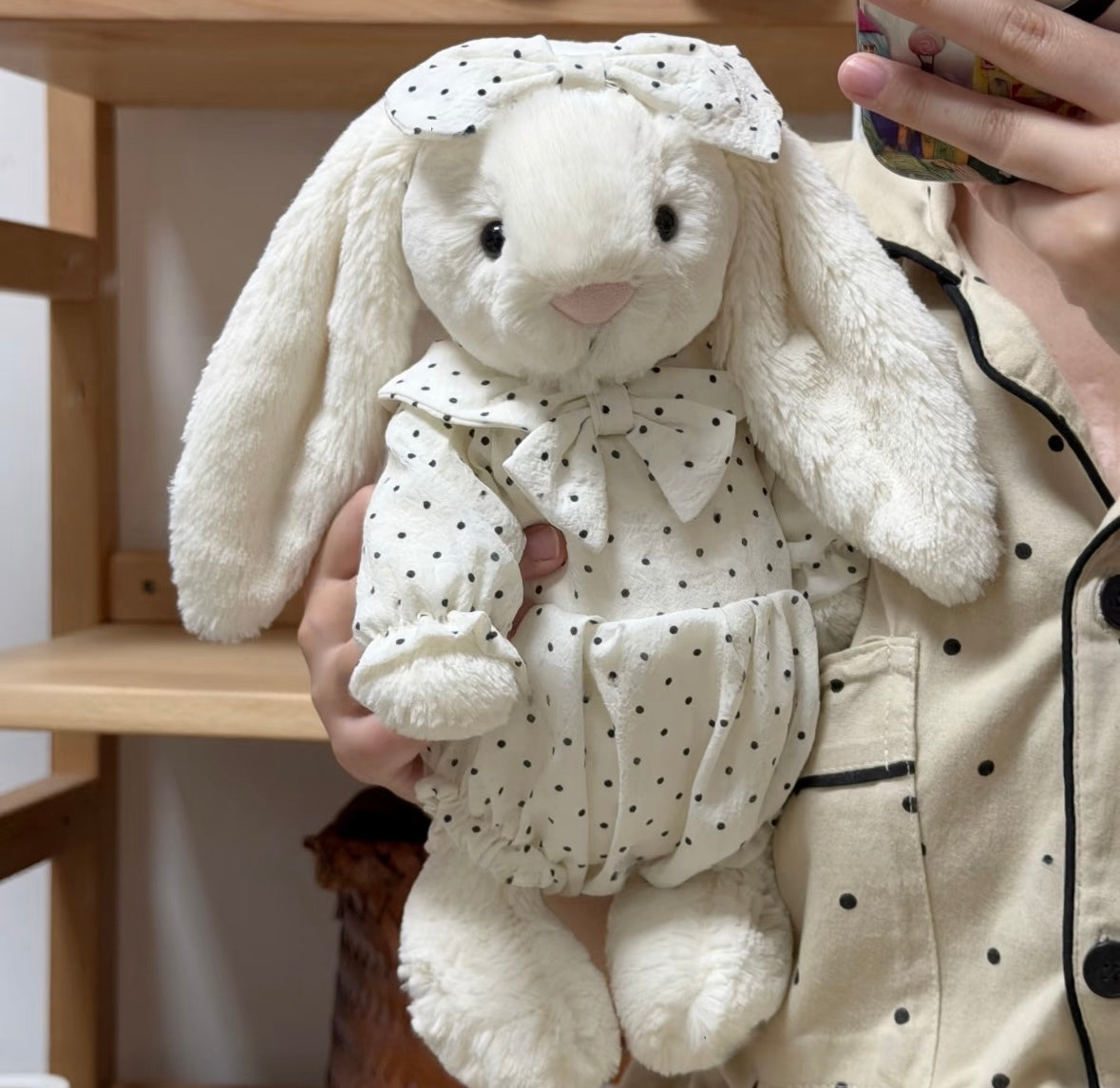 Blue polka dot romper set on white bunny plush - sitting view