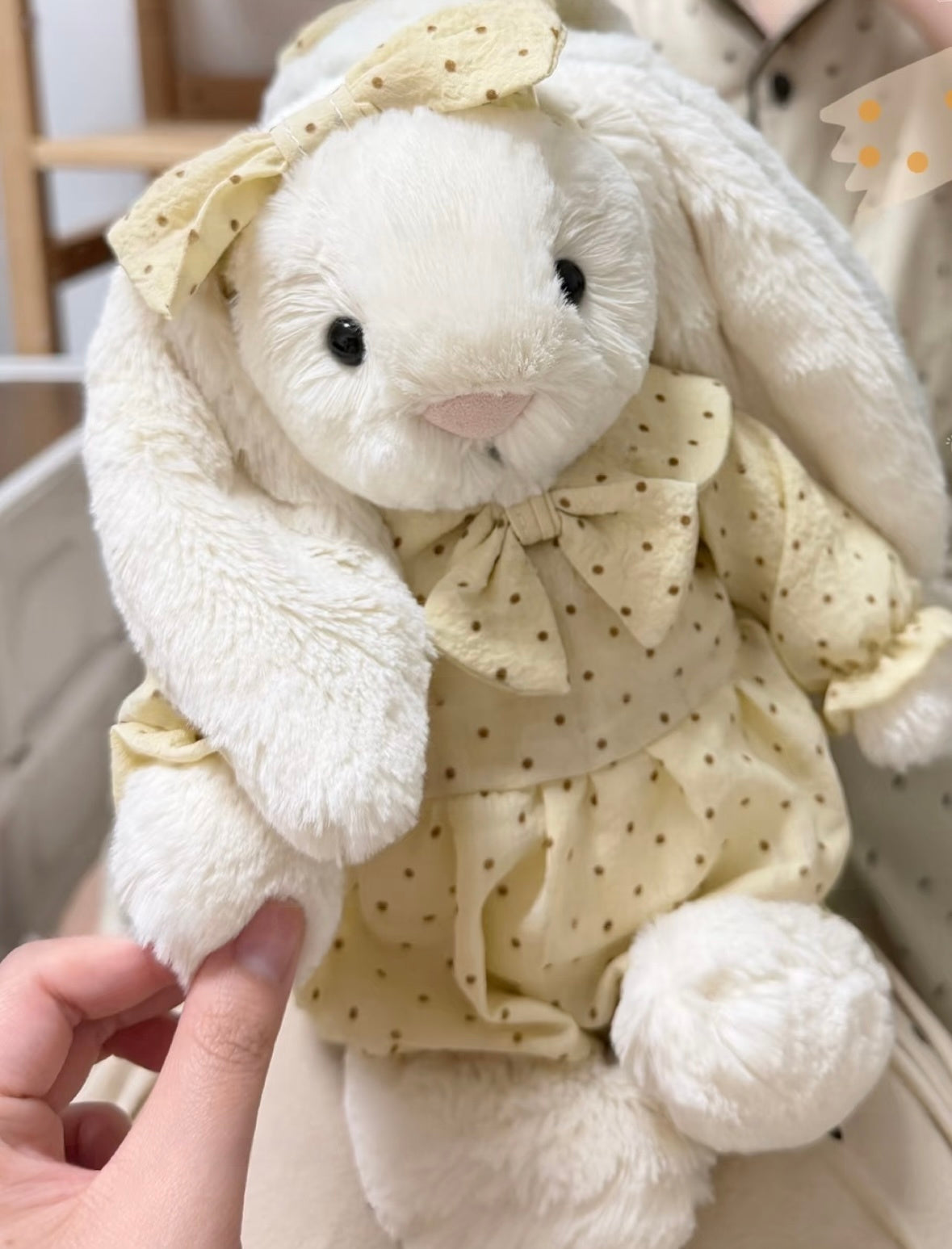 Pink polka dot romper set on white bunny plush - front view