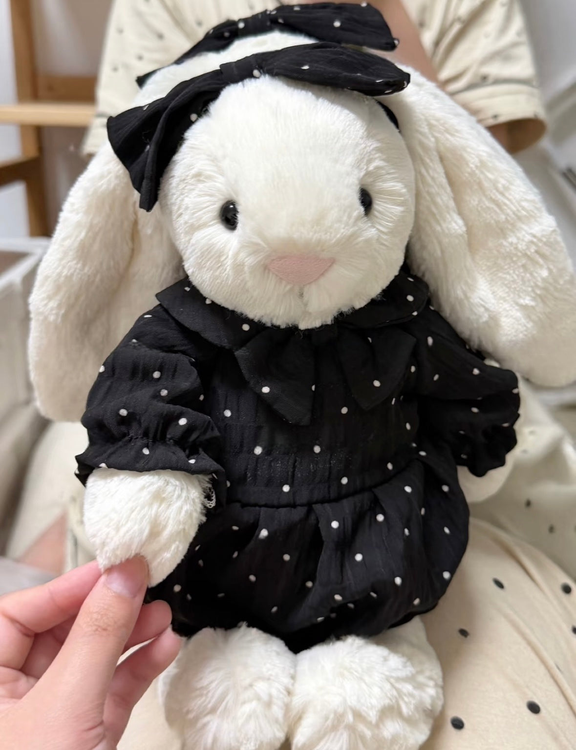 Blue polka dot romper set on white bunny plush - detail view