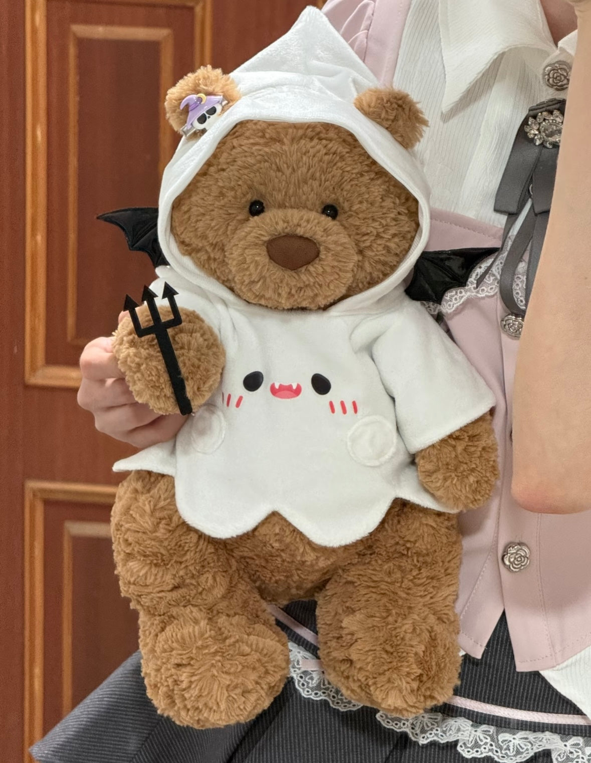 Plush bear in Halloween ghost devil costume being held, showing vampire face and trident detail