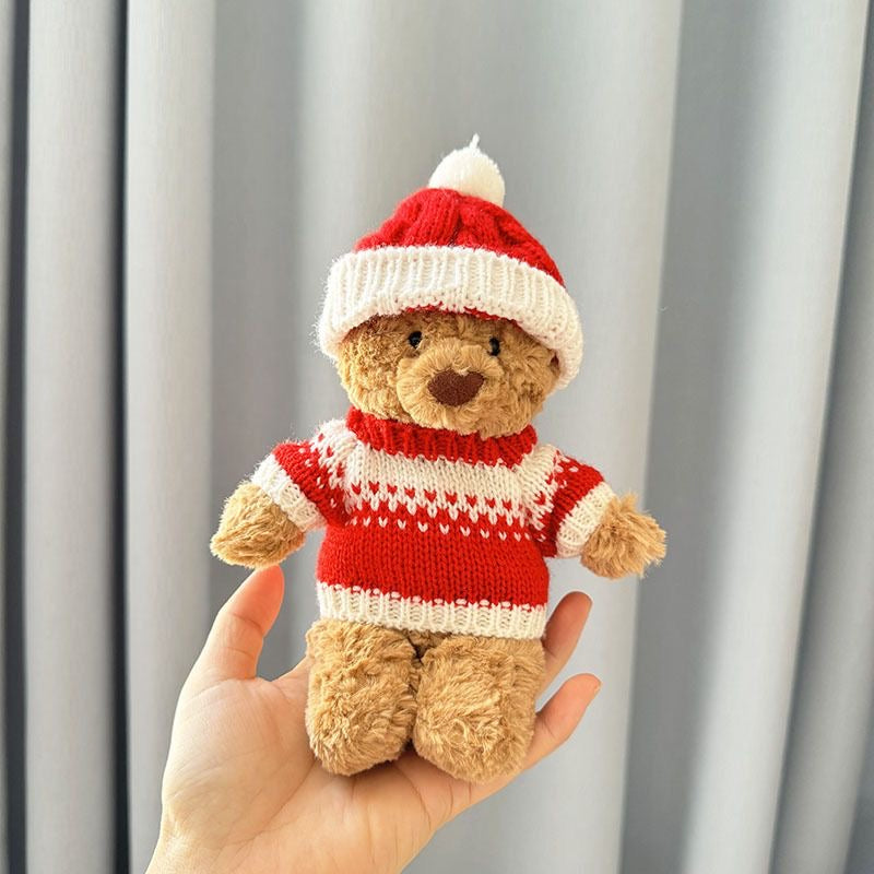 Brown plush bear wearing red and white knitted Christmas turtleneck jumper with matching knitted Santa hat and white pom-pom