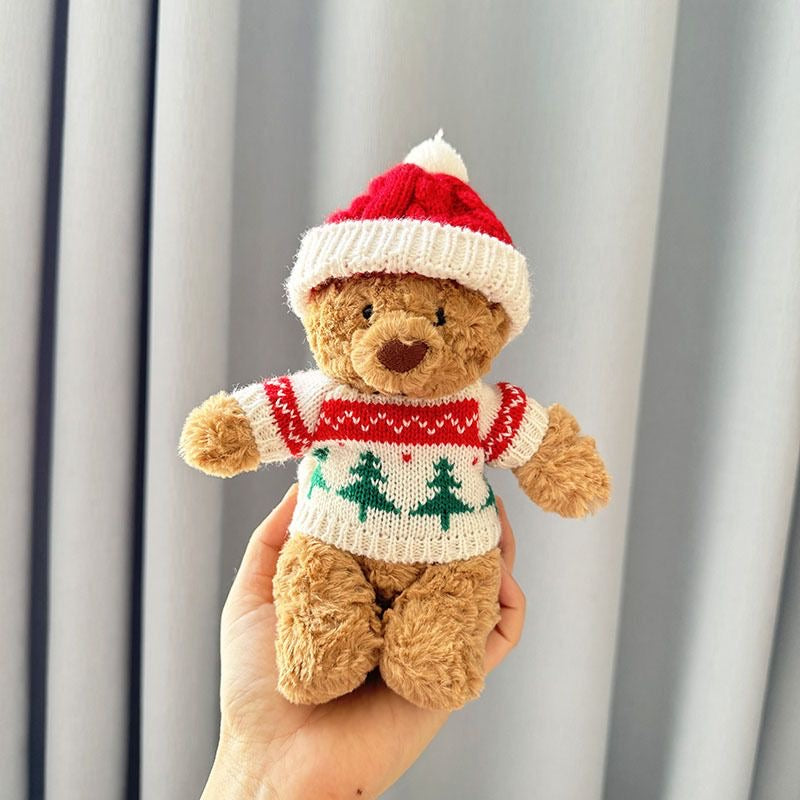 Brown plush bear wearing cream knitted Christmas tree jumper with red stripe and matching knitted Santa hat with white pom-pom