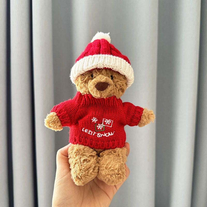 Brown plush bear wearing red knitted Let It Snow embroidered jumper with snowflake motifs and knitted Santa hat with white pom-pom