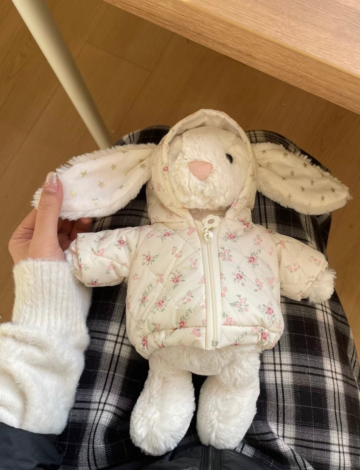 White Bashful Bunny wearing cream floral puffer jacket with hood, laid flat