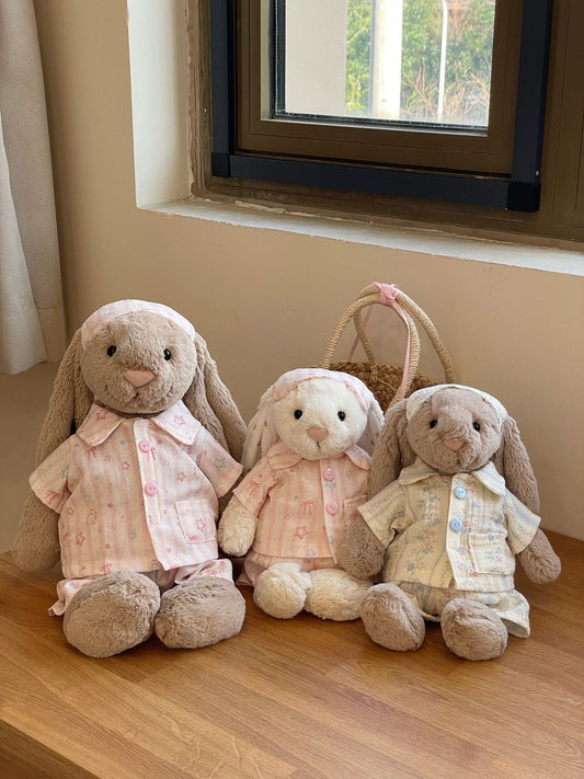 Three Bashful Bunnies wearing different pyjama sets on a shelf